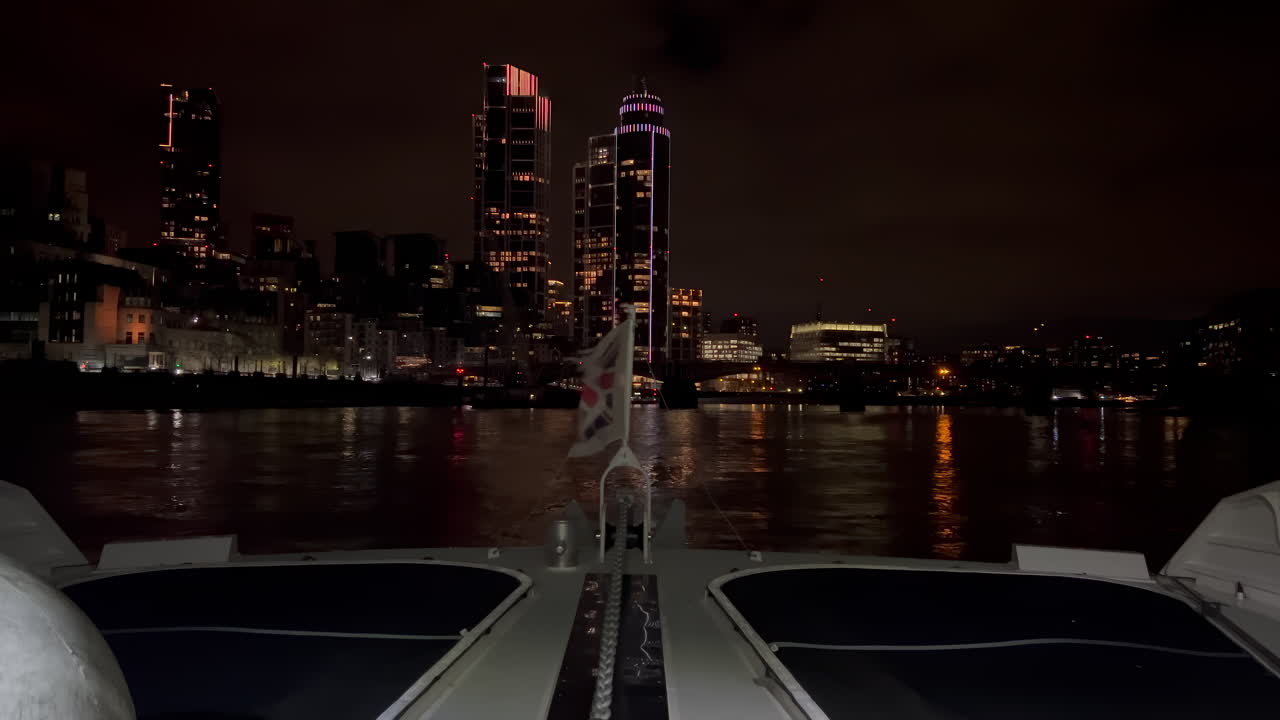 The flag of the United Kingdom waving on a boat moving on the Thames River in the evening in London, England