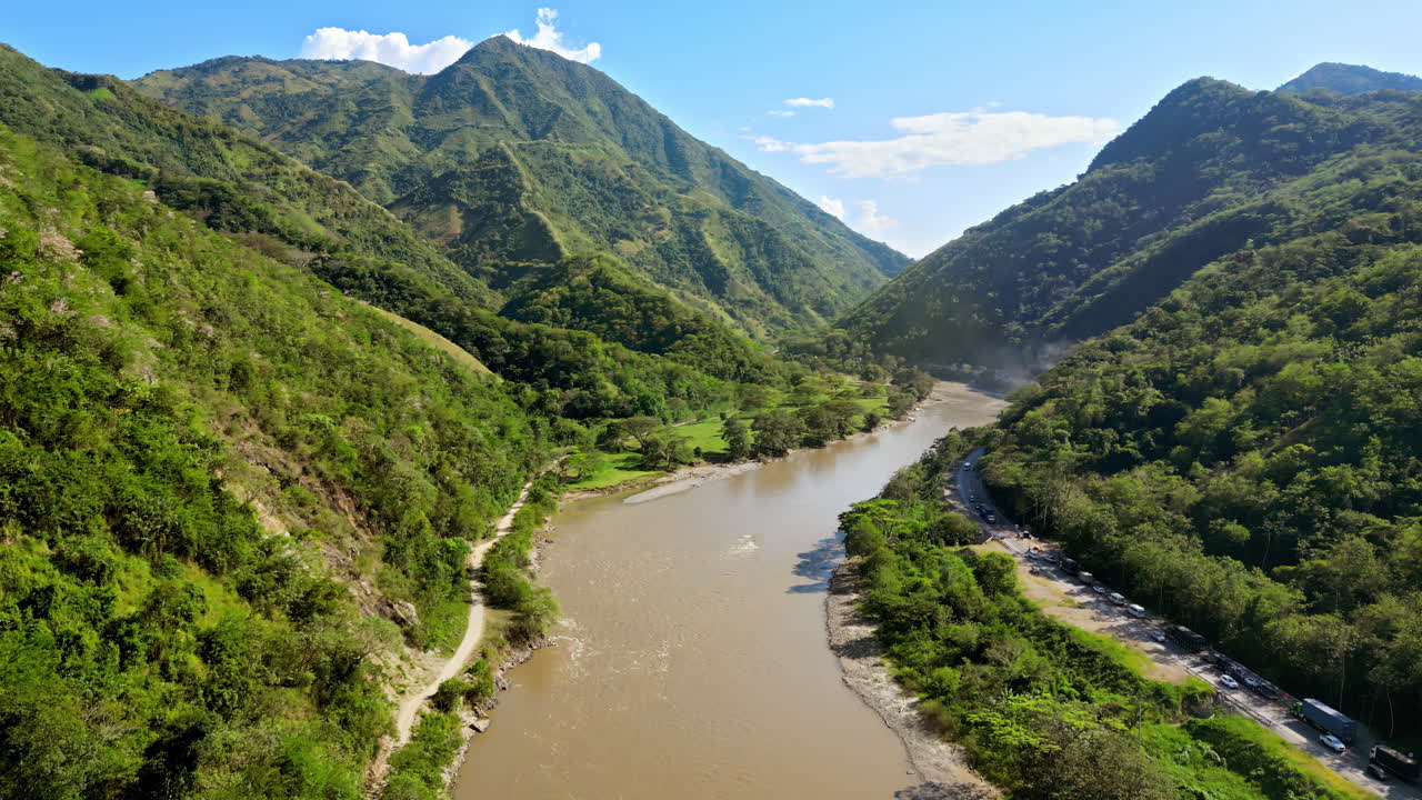 Aerial drone view of the Magdalena River winding through lush green valleys and steep mountain slopes in Colombia