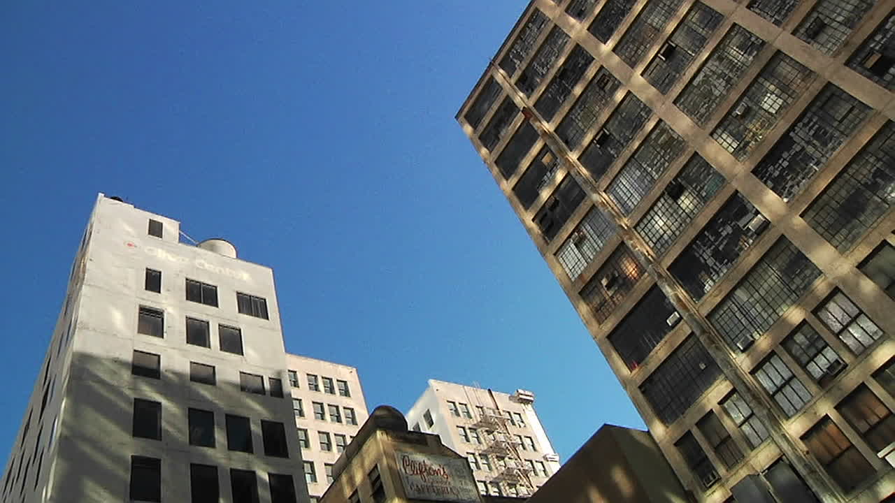 las sombras se arrastran a lo largo del frente de los almacenes y edificios durante la tarde