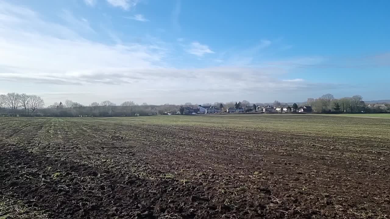 Frisch gepflügter trockener Ackerboden unter sonnigem blauem Himmel am Morgen, bereit für die saisonale Bepflanzung