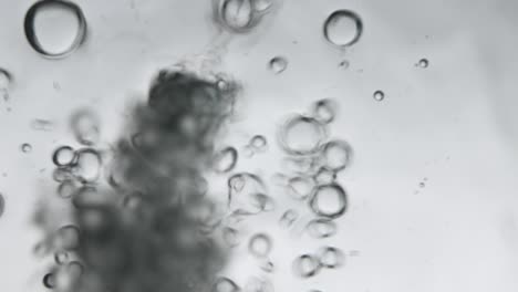 air bubbles in the water while pouring water in glass, photos from the underwater corner. creative abstract background, silver tone style.