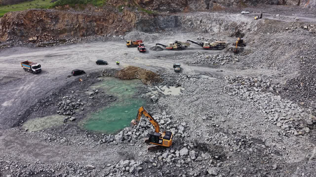 Aerial View of Heavy Machinery Working in a Large Open-Pit Quarry