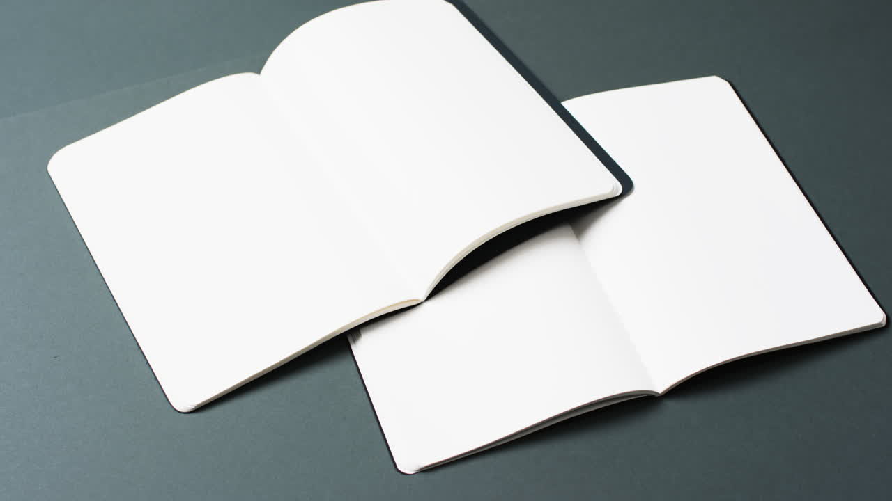 Video of books with white blank pages and copy space on black background