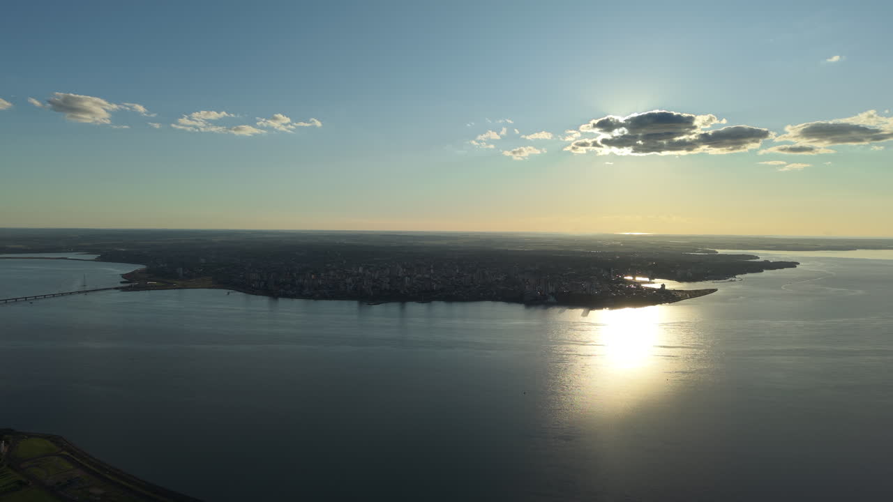 Aerial establishing shot of Paraná river sun reflected on Argentine water coastline of Posadas town, Misiones
