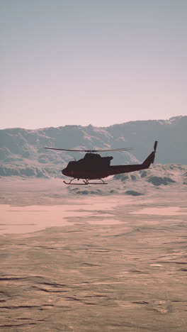 helicóptero volando sobre un paisaje desértico