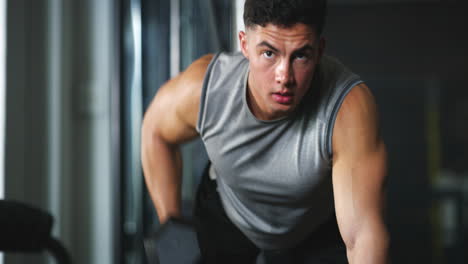 un joven en forma que hace ejercicio con pesas