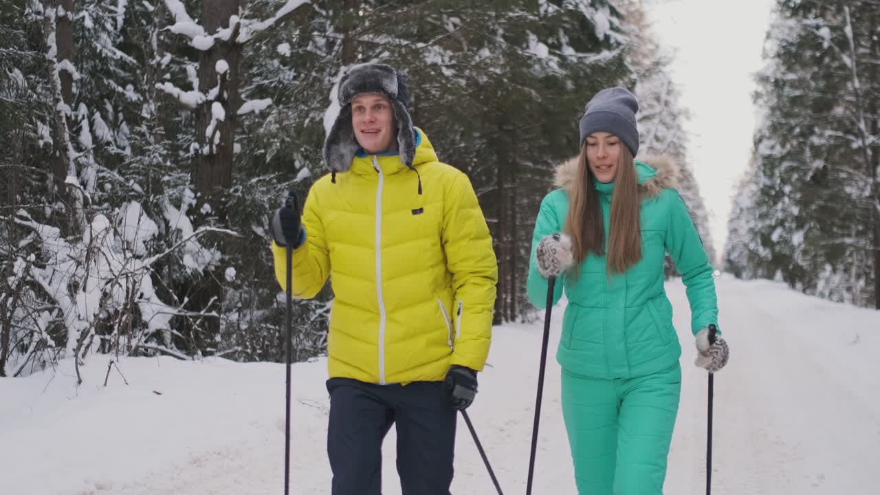 Slow motion shot of a loving couple skiing in the woods on the eve of Valentine's day
