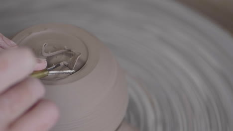 person making pottery on a potters wheel