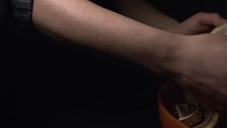 Close-up-of-woman's-hand-showing-homegrown-big-mushroom-harvest-on-black-background