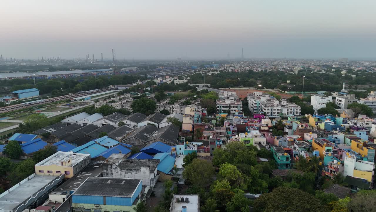 Top-down view of industrial warehouses and parallel train tracks cutting through the city
