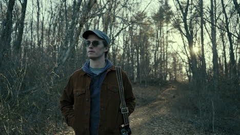 young photographer walks along a wooded path on a winter evening