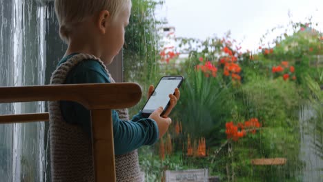 niño usando teléfono móvil en casa 4k