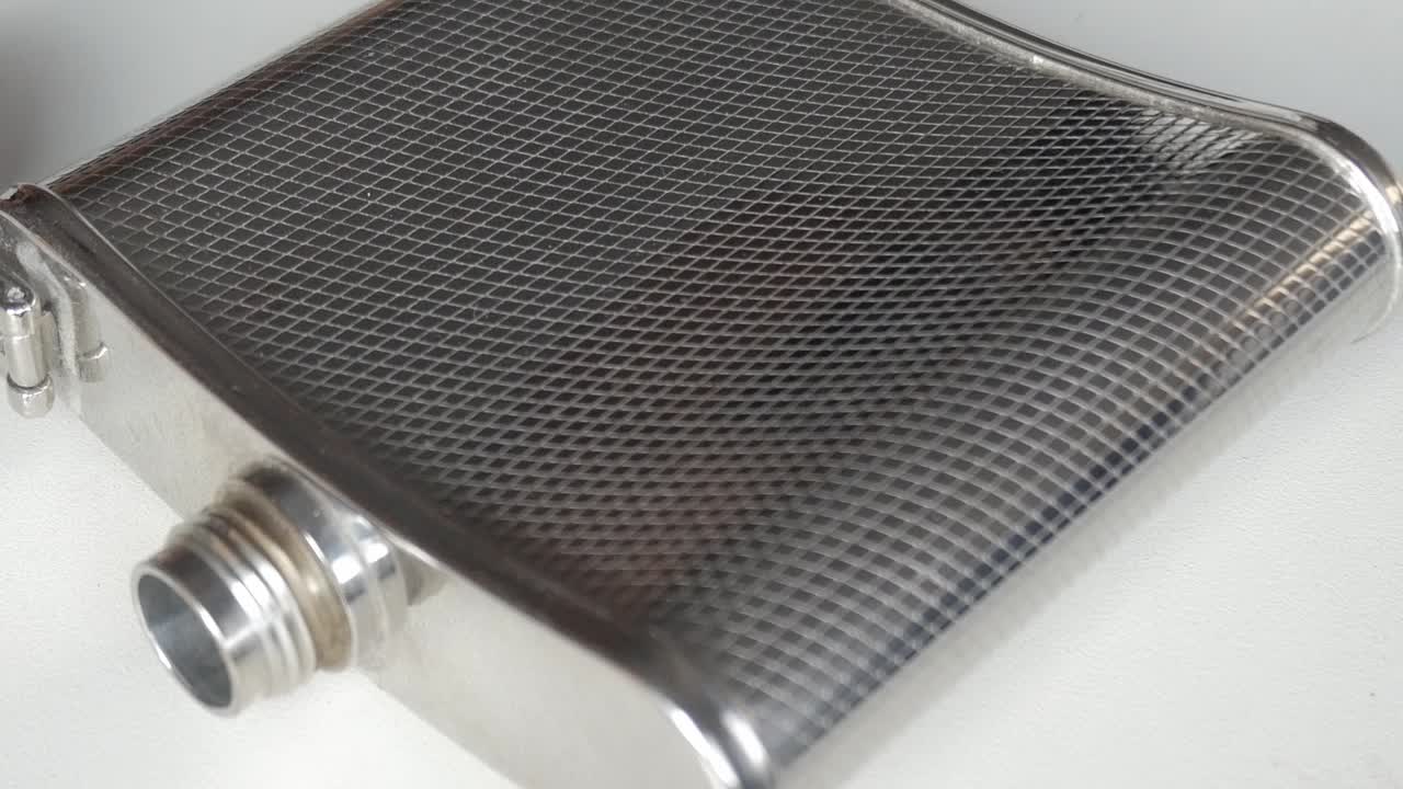 Close-up of a stainless steel flask on a white background