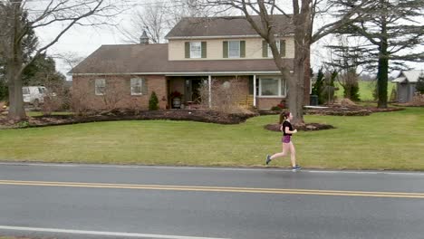 running form and athlete training, female teenage girl trains for marathon on road during winter in pennsylvania usa