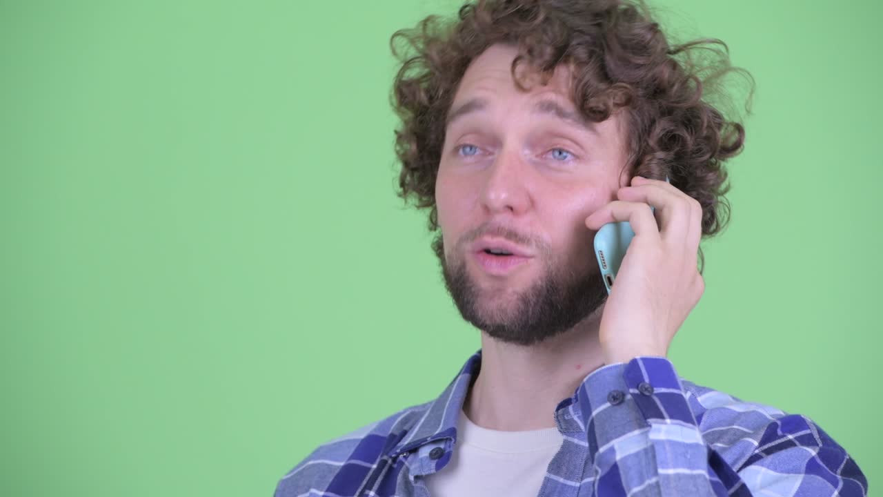 Giovane uomo hipster barbuto e affascinante con capelli ricci