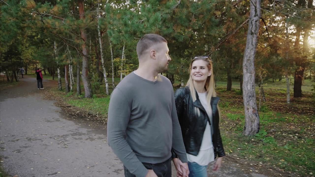 Couple Walking Hand-in-Hand in an Autumn Park