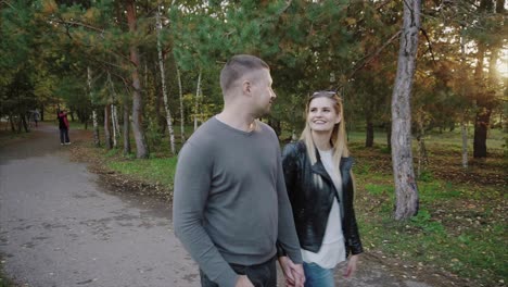 couple walking hand-in-hand in an autumn park