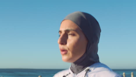 mujer musulmana corriendo en la playa