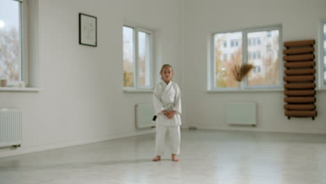chica en kimono blanco en la clase de artes marciales