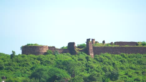 Primer-Plano-De-Un-Antiguo-Fuerte-O-Castillo-Abandonado-Y-Cubierto-De-Un-Espeso-Bosque-Verde-En-La-Cima-De-Una-Colina-En-Madhya-Pradesh,-India