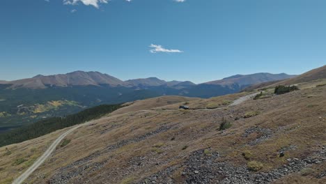 aerial panoramic orbit as car drives along winding dirt path in the rocky mountains peak 10 trail breckenridge colorado