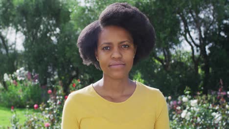 Porträt-Einer-Glücklichen-Afroamerikanischen-Frau,-Die-Im-Sonnigen-Garten-In-Die-Kamera-Blickt