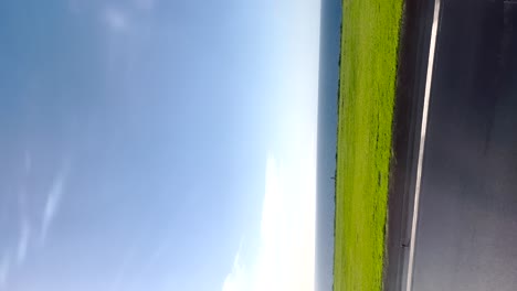 POV-take-off-from-inside-an-airplane-on-a-sunny-day-at-the-airport-with-sea-in-background