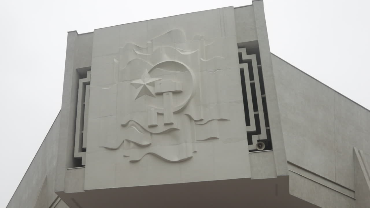 White concrete wall in Sa Pa, Vietnam with a communist emblem featuring a star and crescent moon