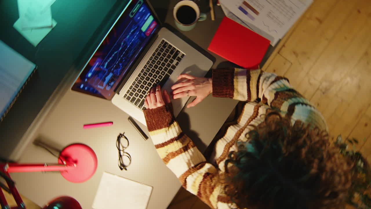 Woman Working with Stock Market Data on Laptop at Night