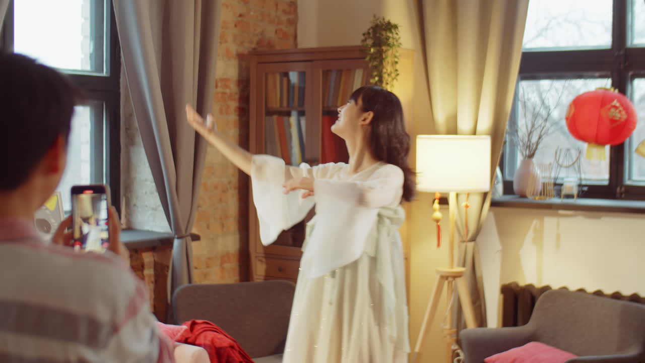 아시아 여성들이 춤을 추고 집에서 비디오를 촬영합니다.