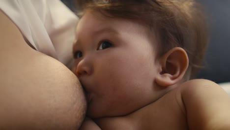 extreme close up of asian baby breastfed by mother