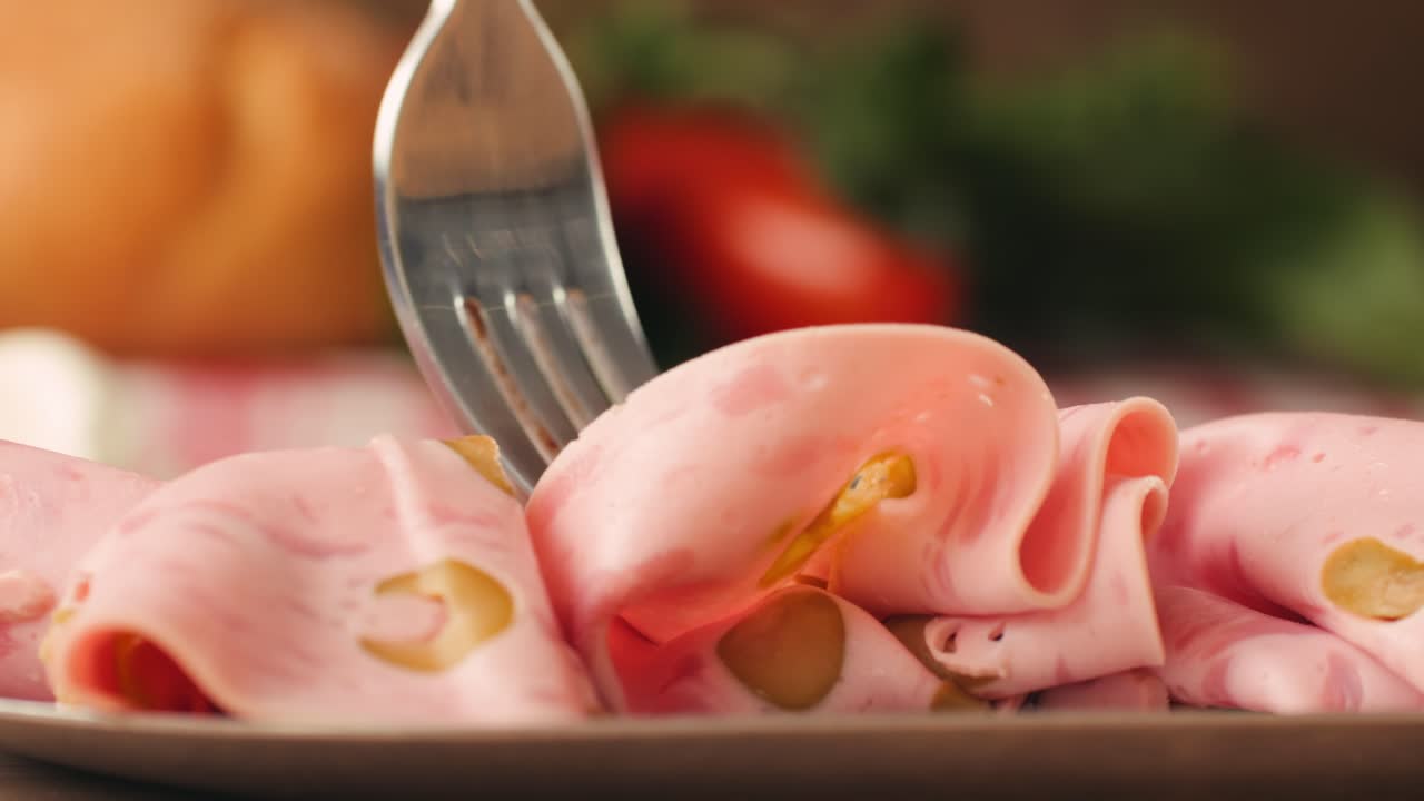 Ham italian mordatella, man Slices Of Traditional Italian antipasti mortadella sausage on a wooden cutting board, close up macro of chicken or turkey jamon, fat breakfast dish.