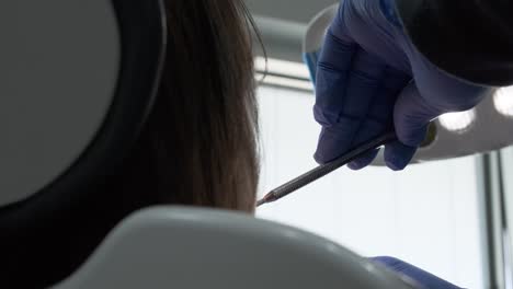 vista de primer plano desde atrás mientras un dentista examina los dientes de un paciente