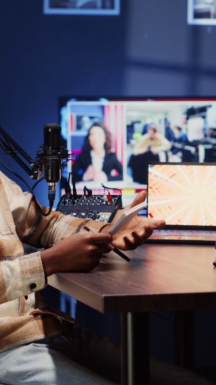 Vertical video Podcast presenter having live discussion with man, using headphones to review music together