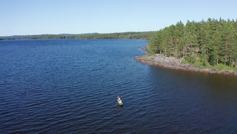 drone shot of crystal clear lake in sweden inland with canoe