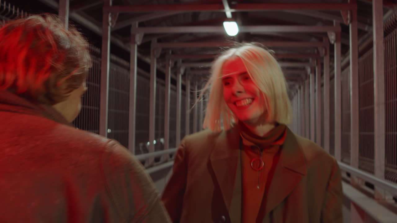 즐거운 커플 이 밤 에 보행자 다리 에서  ⁇ 고 대화 하고 있다