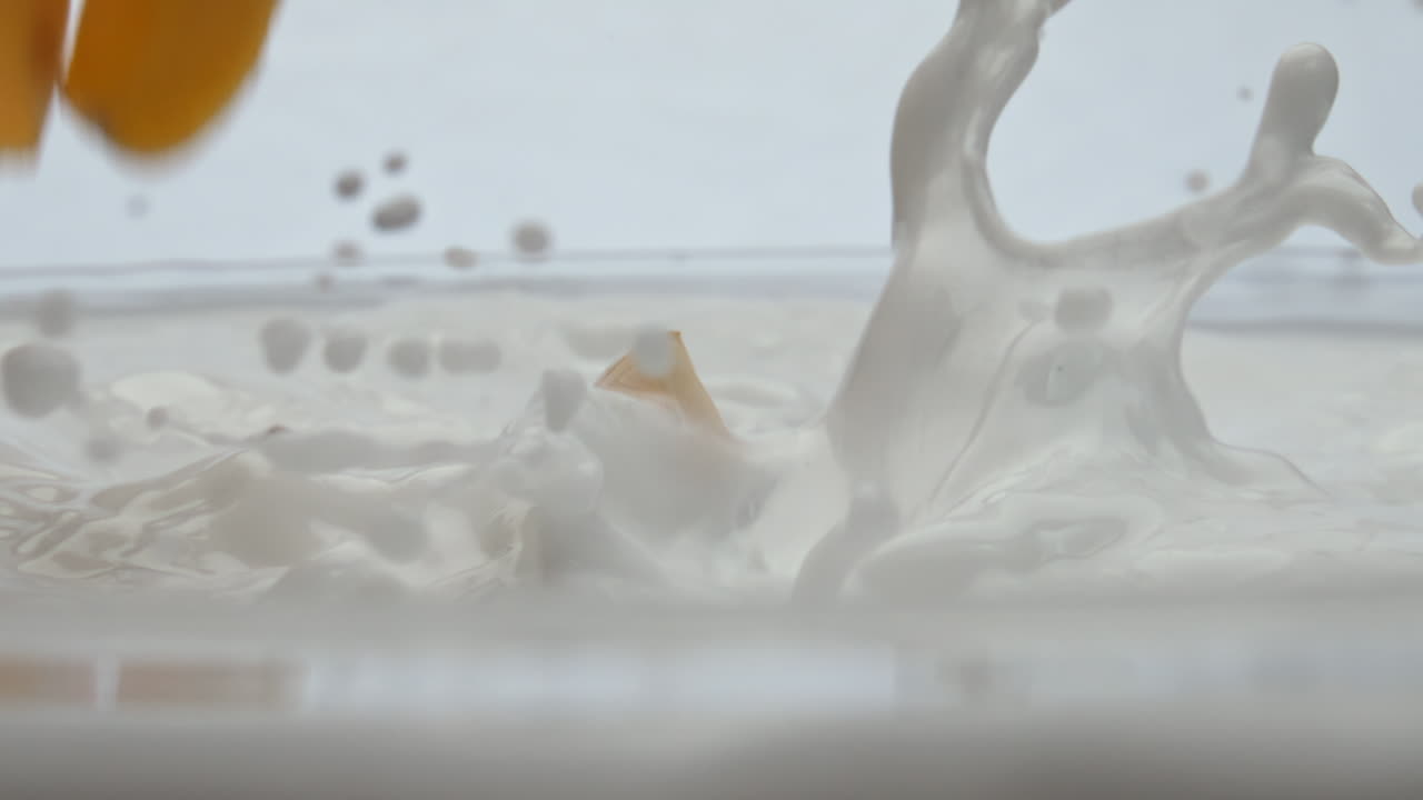 익은 사과가 떨어지는 우유가 슈퍼 슬로 모션으로 가까이 어져 건강한 음식입니다.