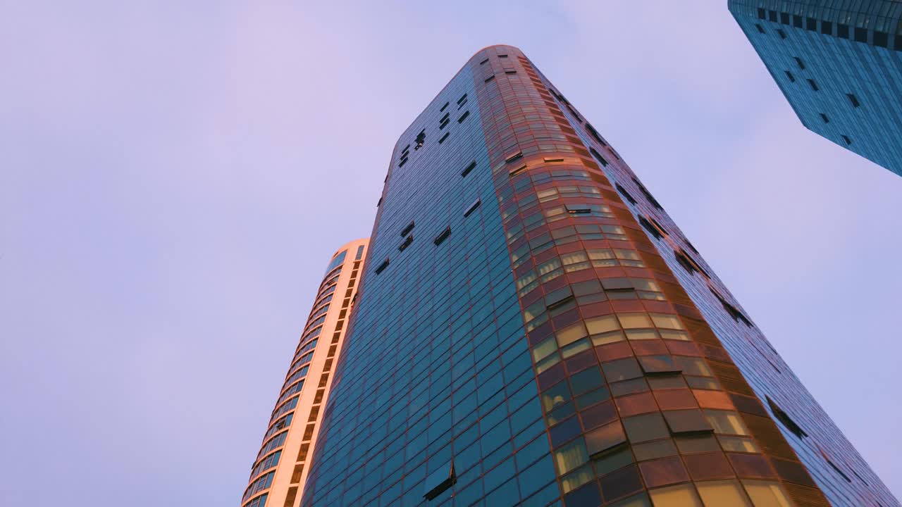fotografía de los edificios de la ciudad de orán con palmeras al costado de la carretera al atardecer.