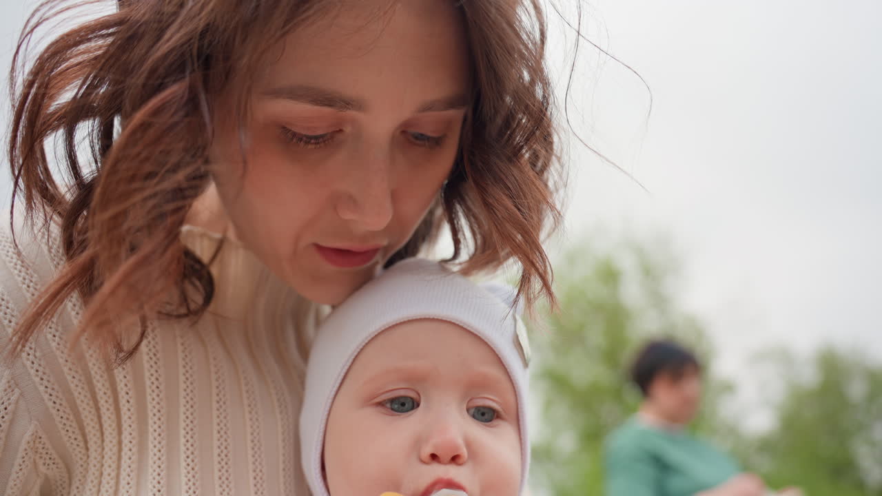 Mother Lovingly Packs Lunch Outdoors, Caucasian Mom Carefully Prepares Snack For Child Outside In Park, Smiling Mother Of Caucasian Descent Lovingly Gets Snack Ready For Playful Baby Outdoors