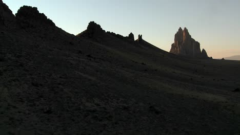 late dusk behind rocky outcroppings near shiprock new mexico