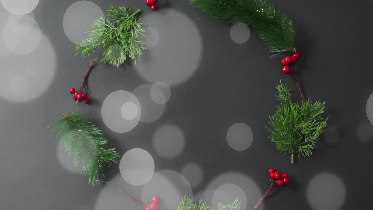 Christmas wreath with red berries and green pine branches over bokeh lights animation