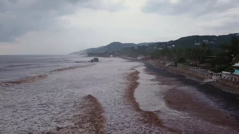 popular lugar de surf, playa el tunco en el salvador, durante un día nublado y nublado - imágenes aéreas de baja altitud - dolly in