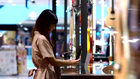 young woman paying by scanning qr code with smartphone