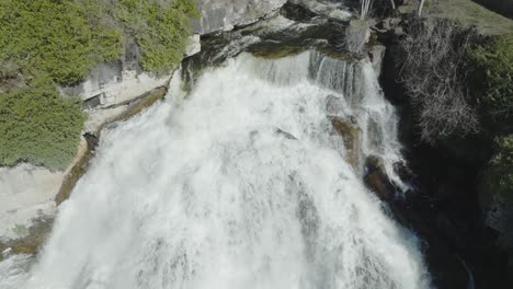 The-powerful-cascading-waterfall-surrounded-by-lush-greenery-in-owen-sound,-canada,-aerial-view