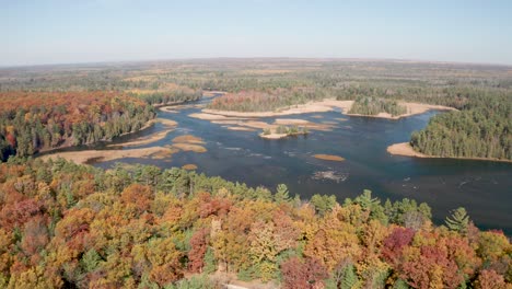 au sable river in michigan with fall colors and drone video moving over trees