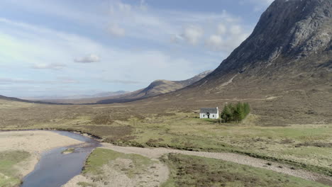 Aerial-footage-of-a-small-hikers-cottage-in-Glencoe,-Scottish-Highlands