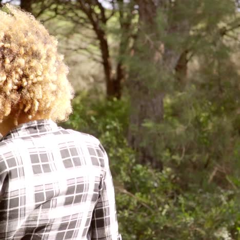 vista trasera de una mujer que camina por el camino forestal