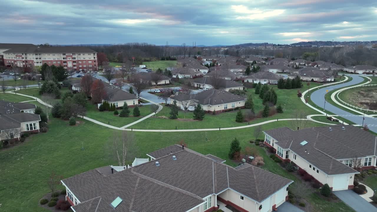 grandes villas inmobiliarias de lujo en el suburbio de la ciudad americana. camino en el área del parque durante el día nublado de otoño. garaje doble y camino de entrada. drone en ascenso disparo ancho.