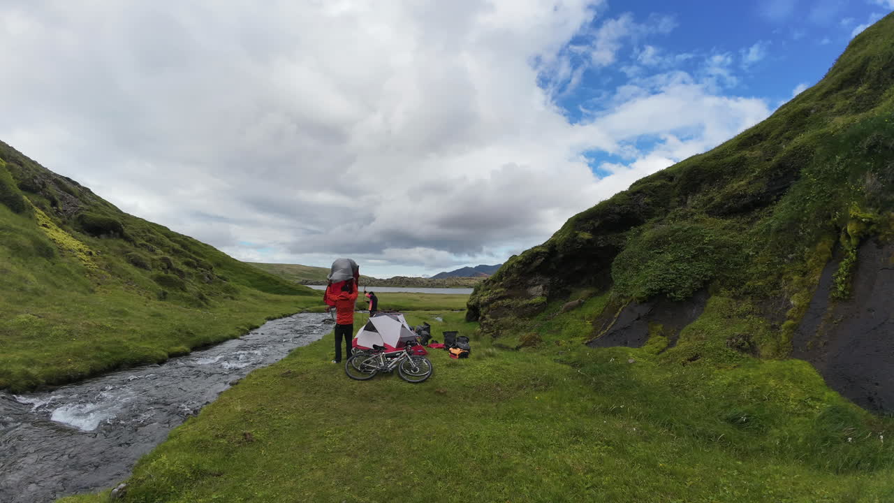 Dynamic timelapse showing two individuals dismantling their campsite at Selvallafoss, Iceland, against the backdrop of this famous waterfall's natural beauty.