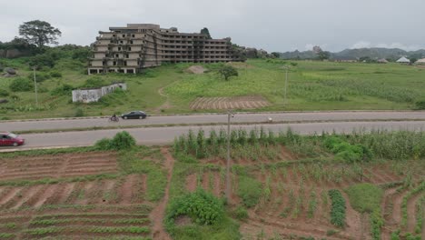 aerial - abandoned hotel building and lamingo dam, jos plateau, nigeria, descending